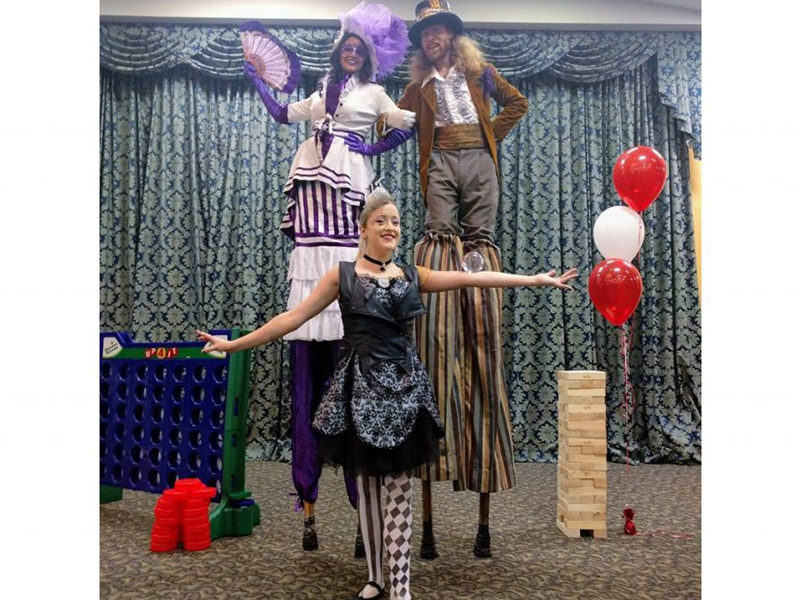 Two themed Stilt Walkers posing for photos.